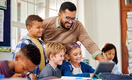 A man with children showing them something on a laptop